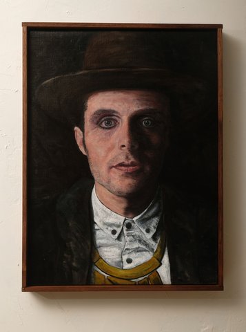 Oil on linen portrait of a young man in a dark hat, white button-up shirt, and yellow suspenders, dramatically lit against a black background.