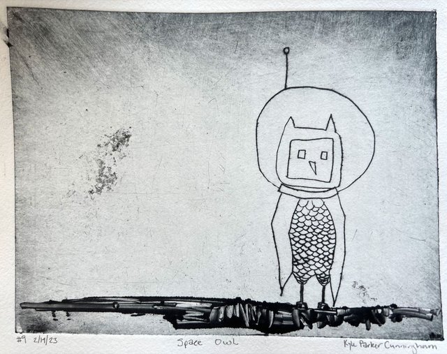 Intaglio drypoint print of a whimsical owl wearing a round space helmet with an antenna, its body covered in feathery scales, standing on a dark branch against a scratched gray background on handtorn paper.